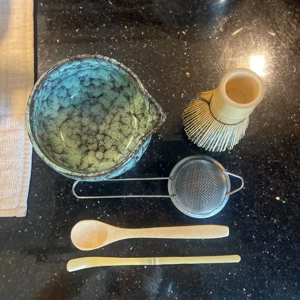 Cyan matcha set flat lay on a black granite countertop