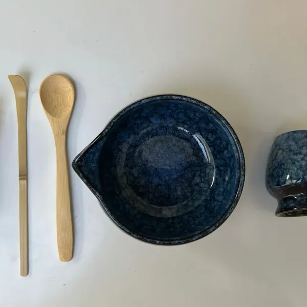 Blue ceramic matcha set laid out flat by a customer, all six pieces visible